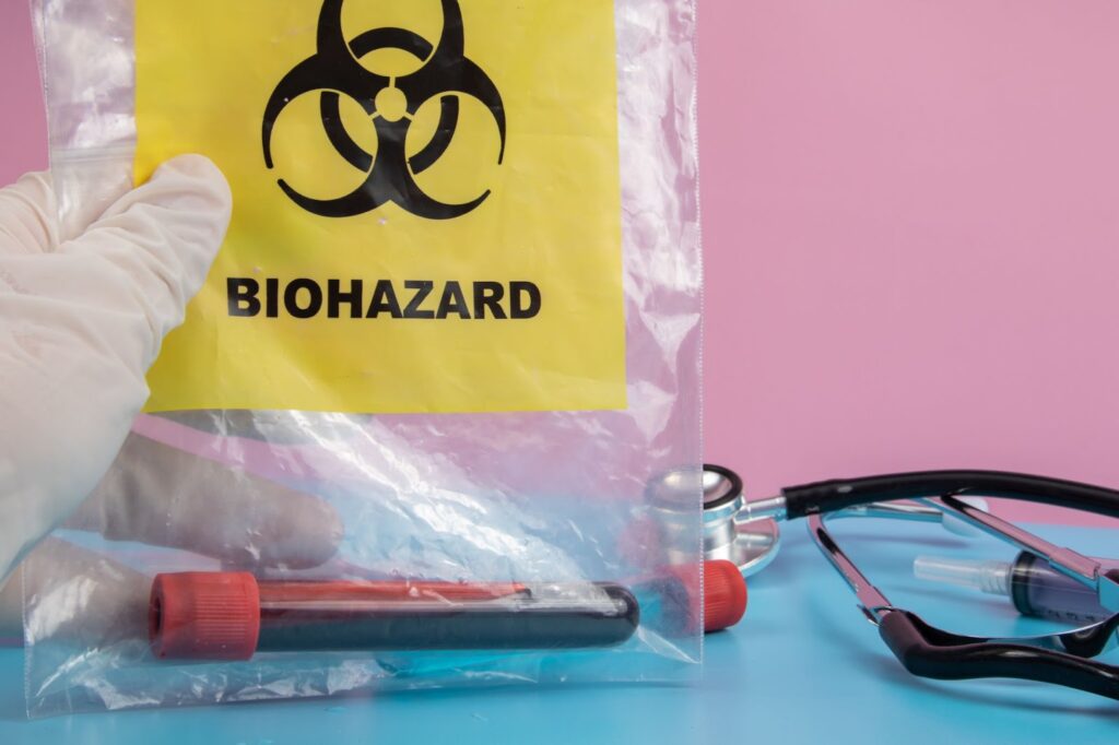 Biohazard cleanup tools on blue table - Bloodborne Pathogens, professional cleanup