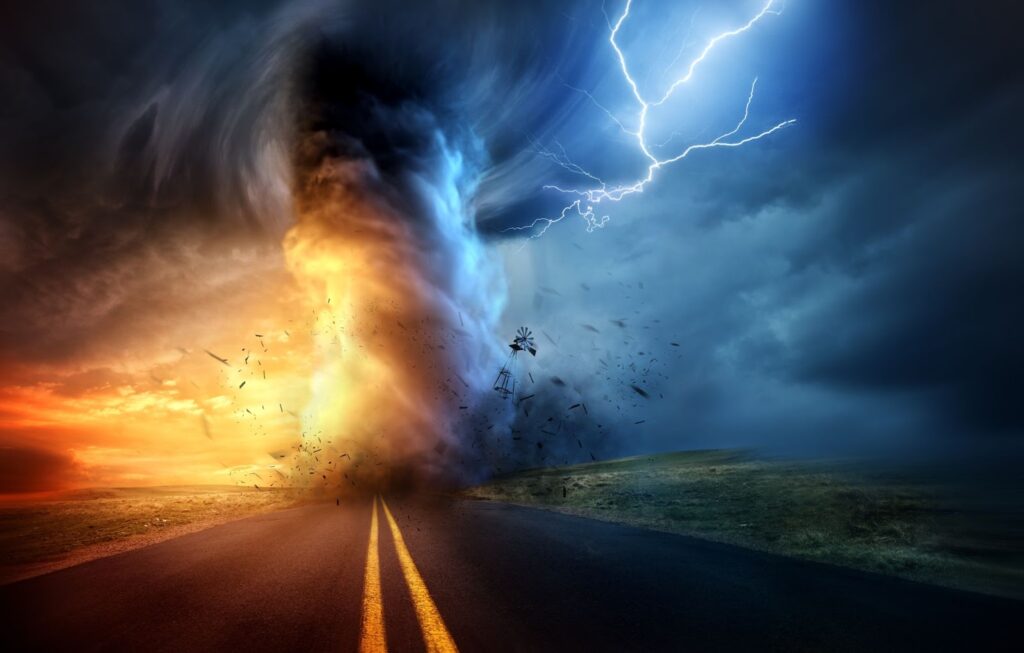 Image of a tornado touching the sky as it moves down a road